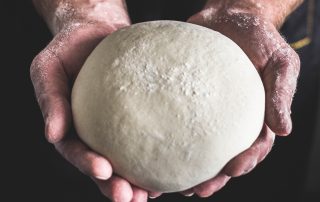 hands holding dough for Marshall's rustic country bread recipe
