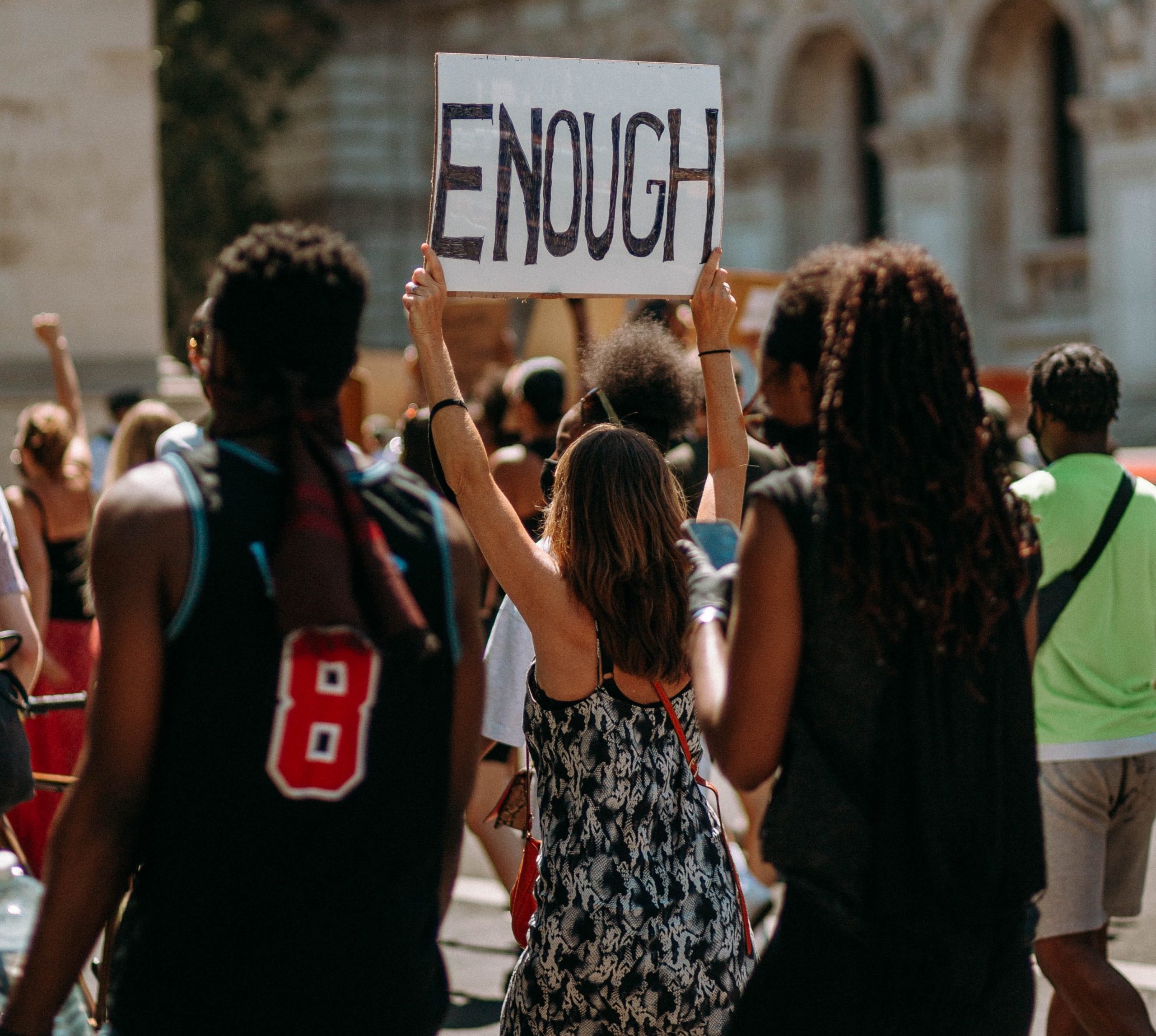 Activists walk with a sign that says "Enough"